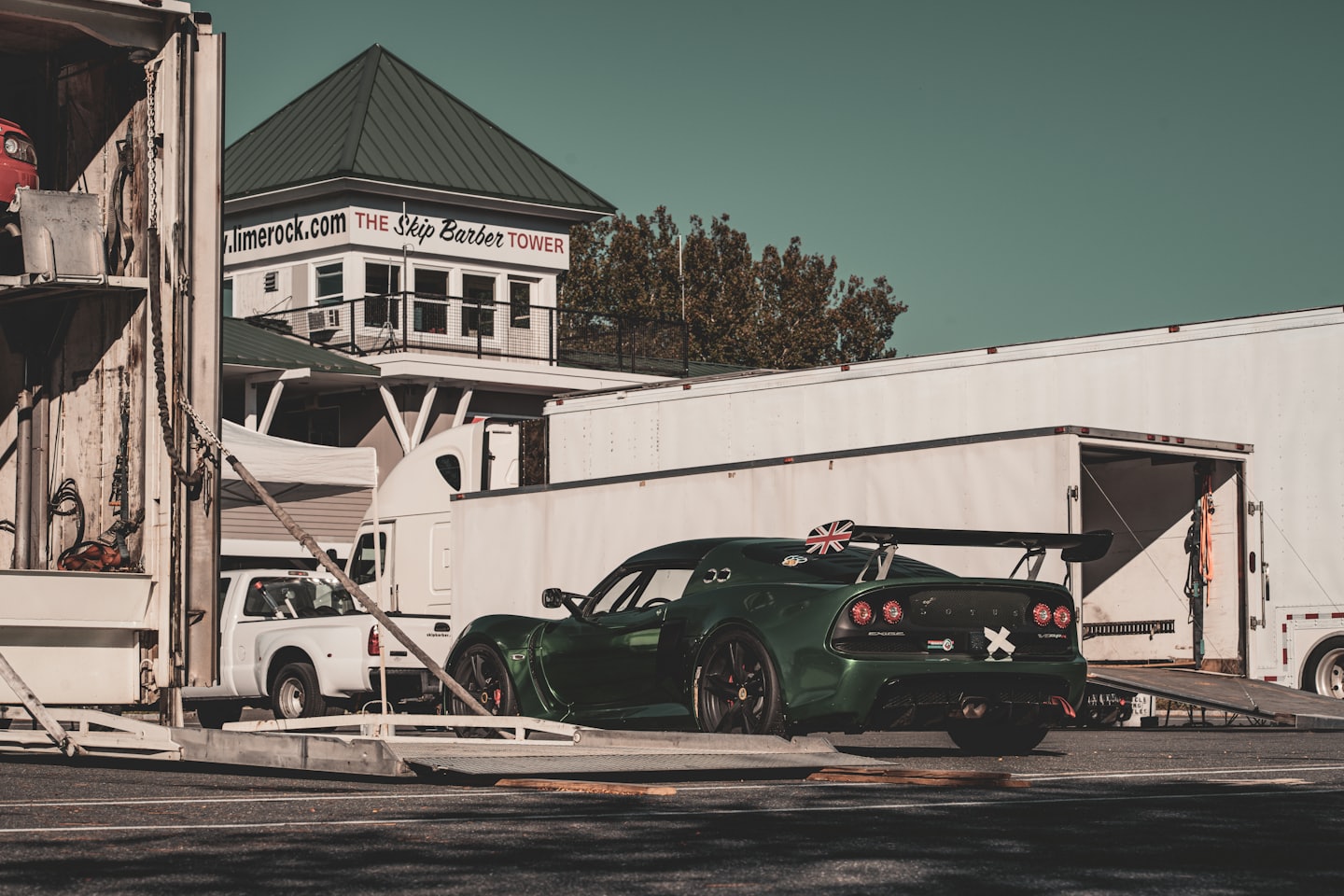 Sportwagen an einer Fahrzeugrampe vor Lager- und Containergebäuden – Darstellung von Transportprozessen und Logistikdienstleistungen.